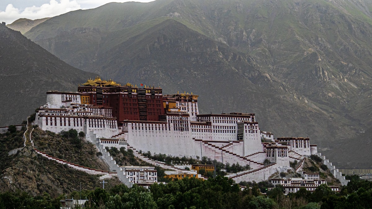 Potala Palace rising above Lhasa at golden hour — the defining red-and-white UNESCO World Heritage site on the Tibetan Plateau