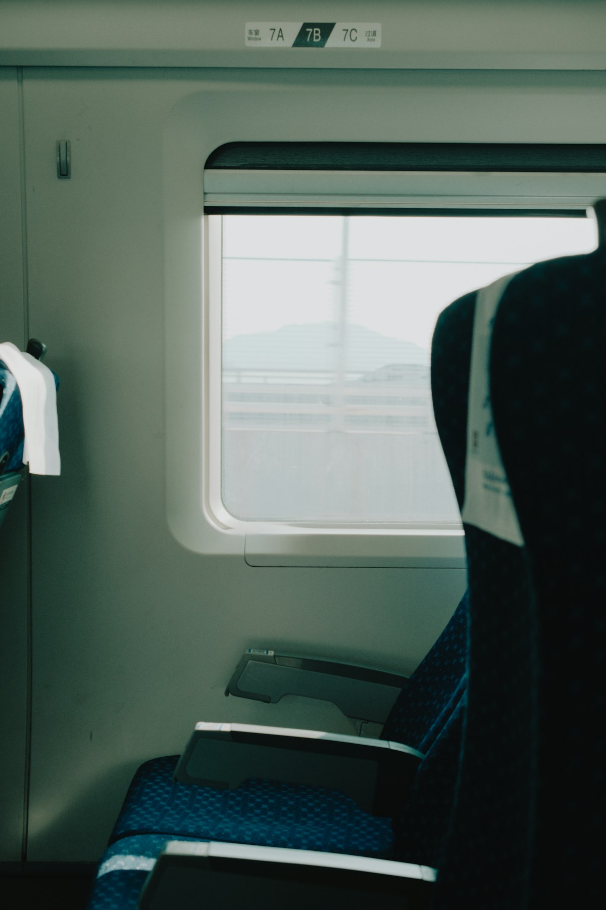 China high-speed train second class interior — 3+2 seating layout with generous legroom, power sockets, and tray tables
